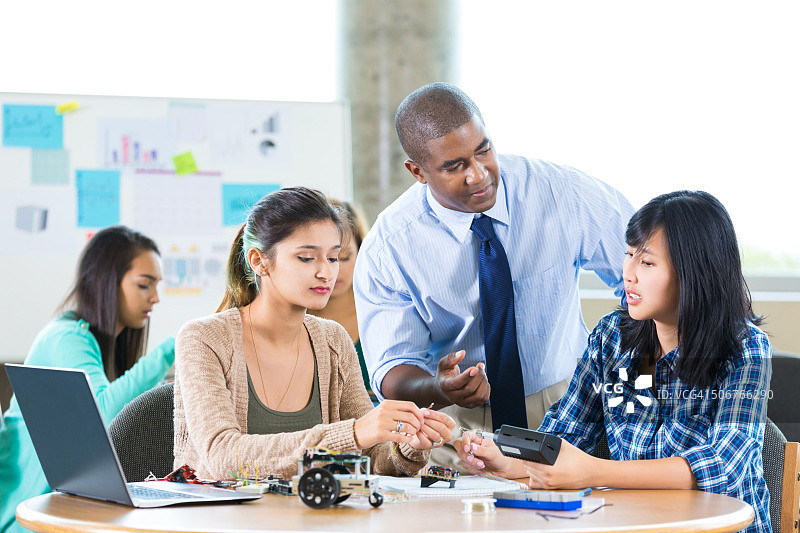 男教师在STEM学校指导学生图片素材