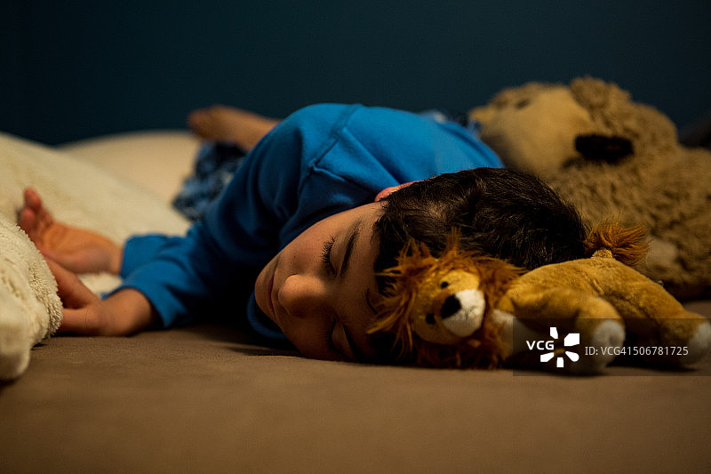 小男孩抱着玩具老虎睡觉图片素材
