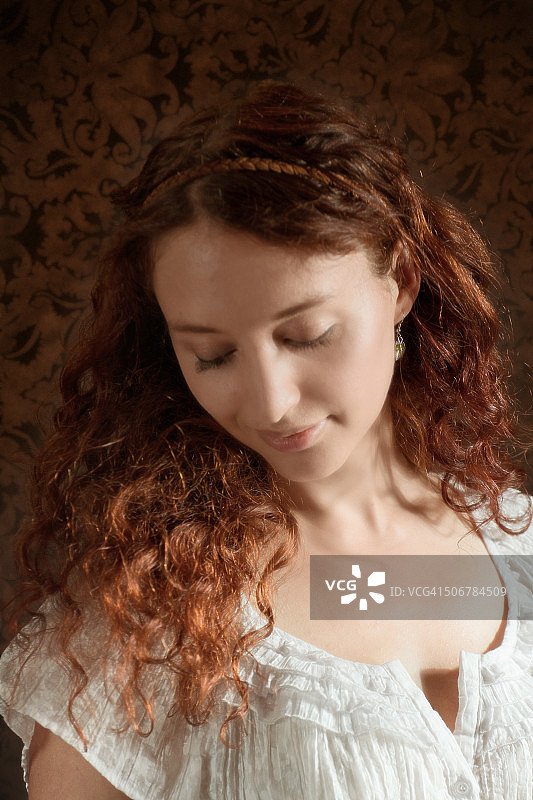 红发女子对着肩膀微笑，锦缎背景图片素材