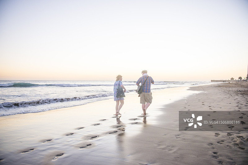 一对情侣在海滩上散步图片素材