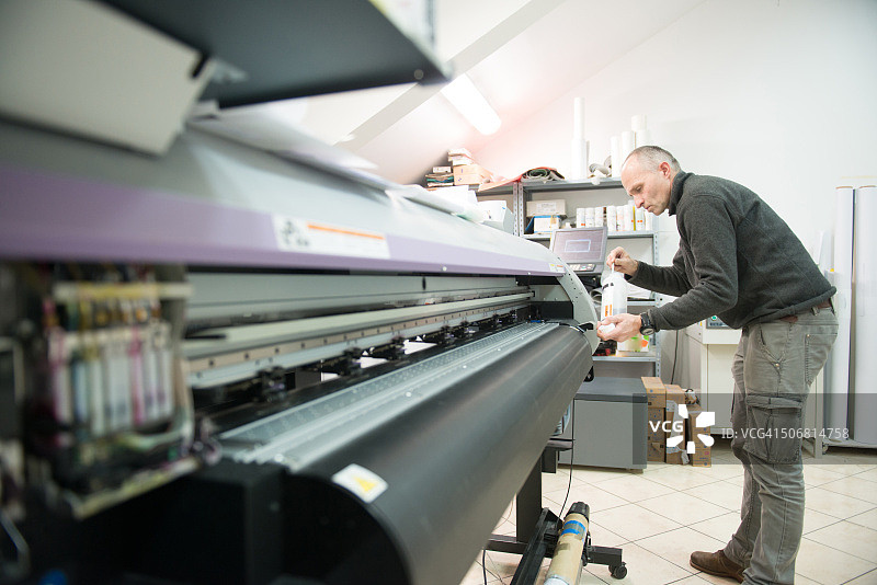 男子清洁大幅面打印机头图片素材