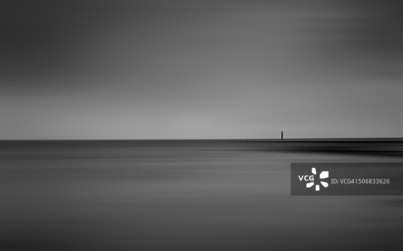 极简主义海景，一人站在码头上图片素材