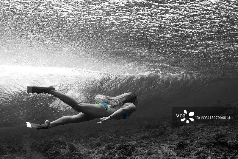 女孩在水下游泳，海浪拍打图片素材