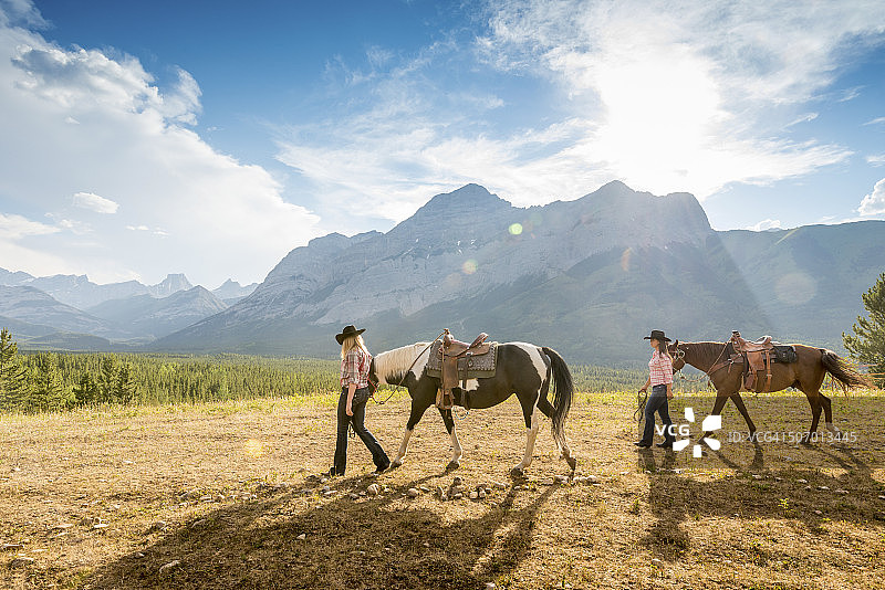 女牛仔们带领马匹穿过山地牧场图片素材