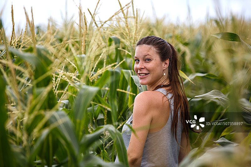 在玉米地里微笑的长发女子图片素材