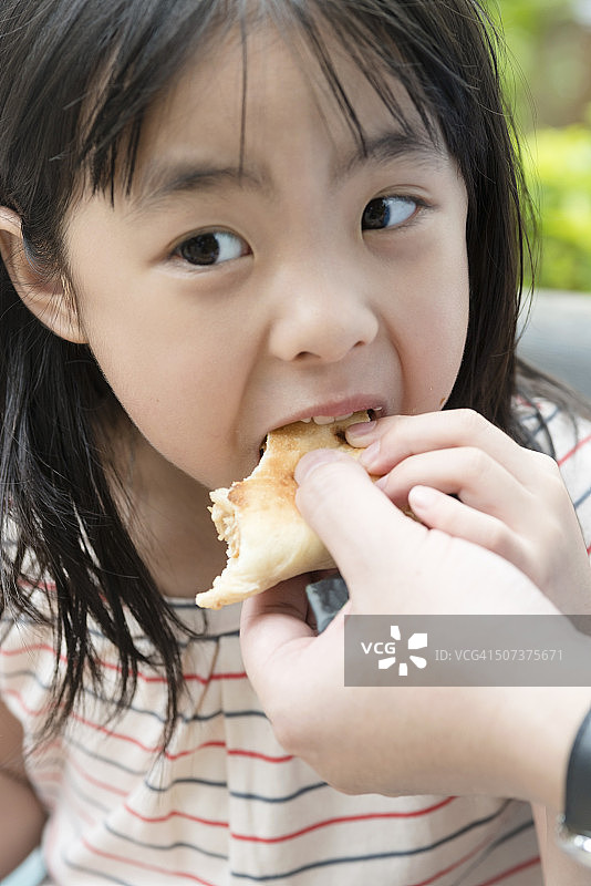 在香港公园吃三明治的中国女孩，亚洲图片素材