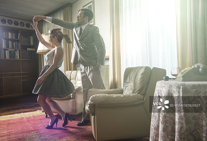 年轻情侣在客厅跳摇滚舞图片素材