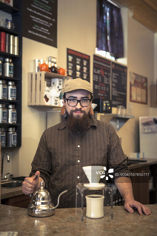 咖啡师在咖啡馆柜台上提供咖啡的肖像图片素材
