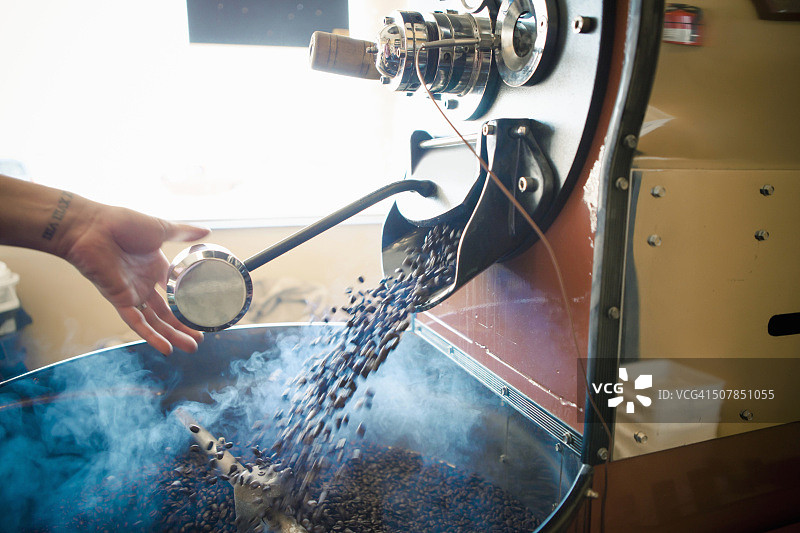 女人在咖啡馆使用工业咖啡烘焙机图片素材