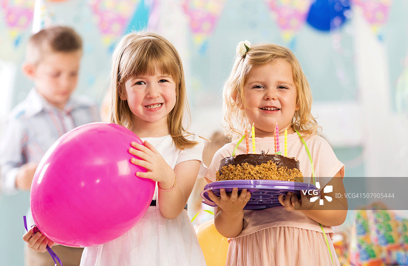 可爱的小女孩们拿着生日蛋糕和气球图片素材
