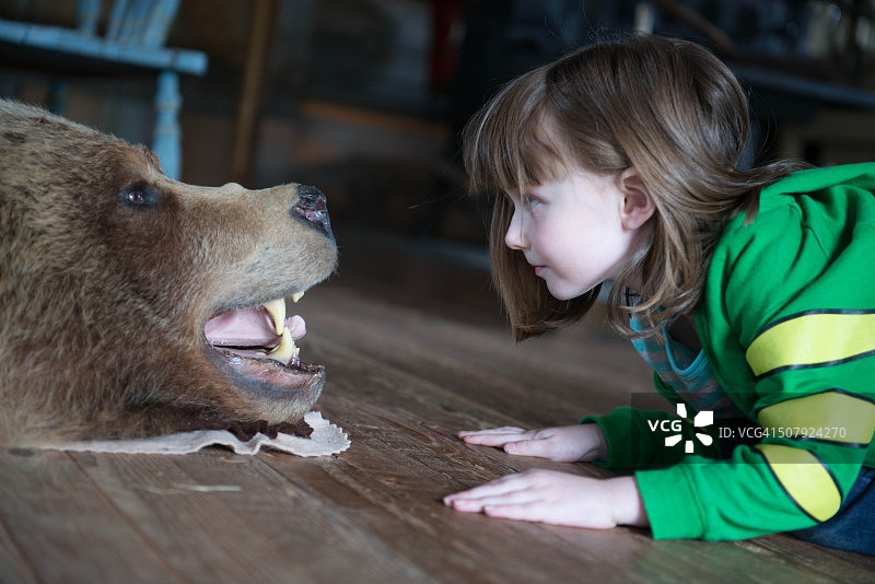 看着熊皮地毯的小女孩图片素材