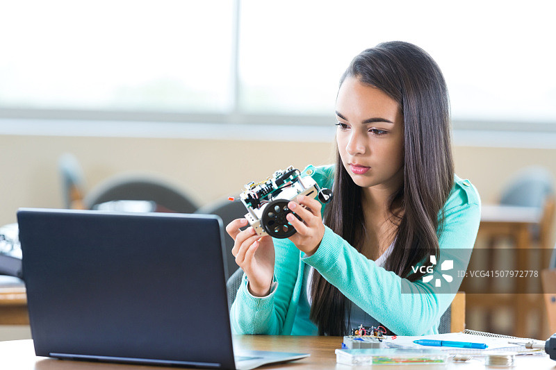 西班牙裔女高中生在工程俱乐部研究机器人图片素材