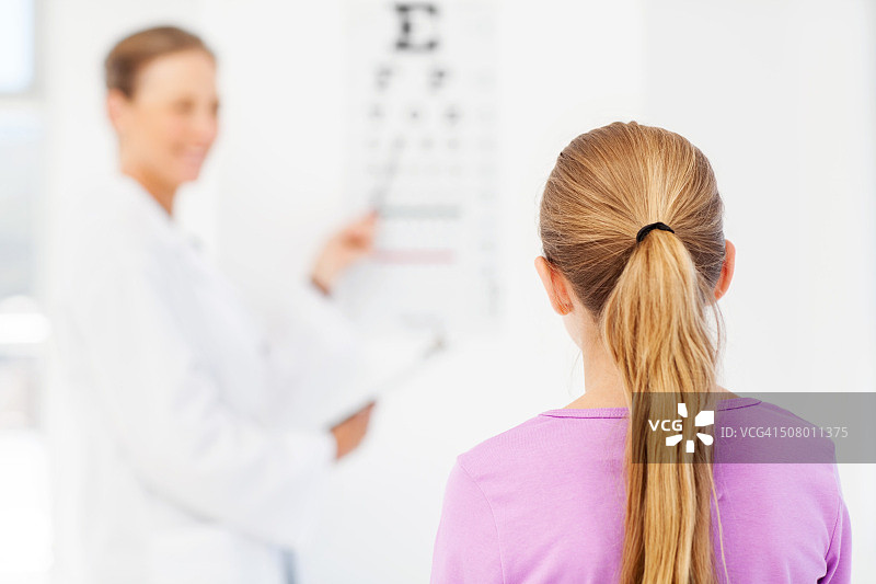 女孩在儿科医生办公室看视力表图片素材