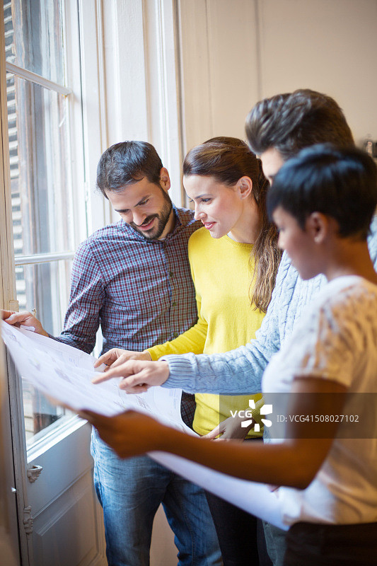 年轻建筑师团队查看蓝图图片素材