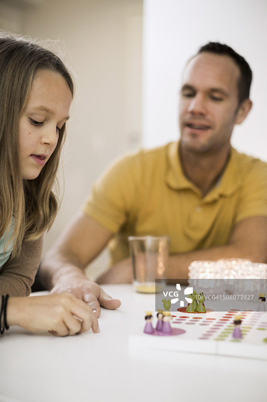 父女在咖啡桌旁玩飞行棋图片素材