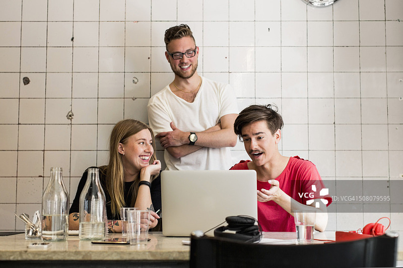 年轻的商业人士在创意办公室通过笔记本电脑讨论图片素材