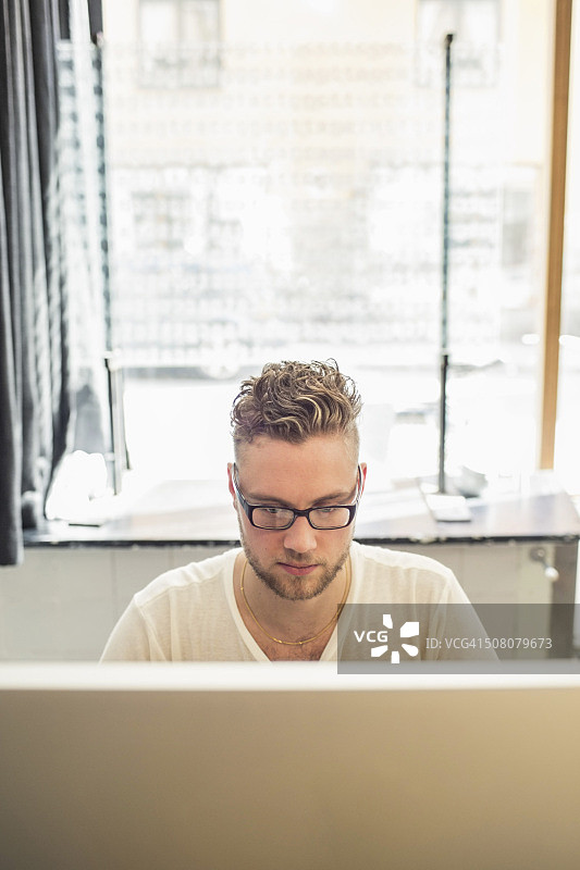 在创意办公室使用电脑的年轻商人图片素材