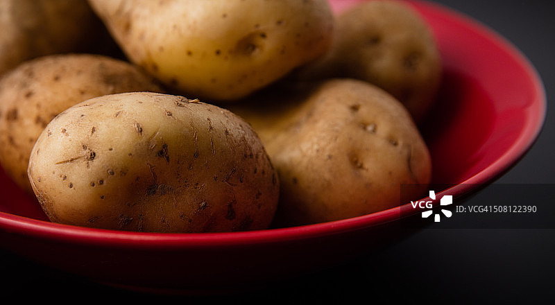 深红色盘子里的土豆图片素材