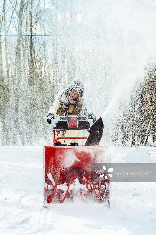 少女用扫雪机扫雪图片素材