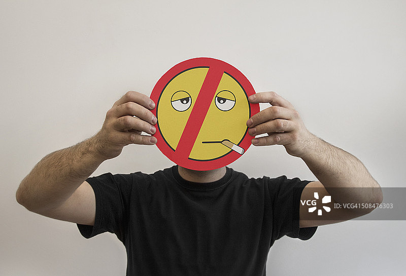 男人拿着一个禁止吸烟的表情符号图片素材