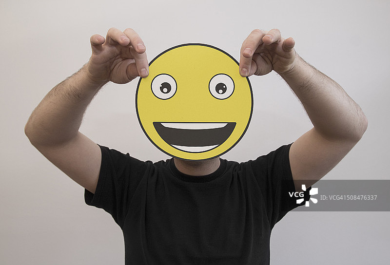 男人拿着一个非常快乐的表情符号图片素材