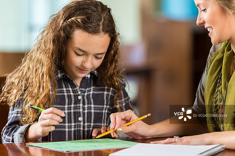 做数学作业或在家学习的小学年龄女孩图片素材