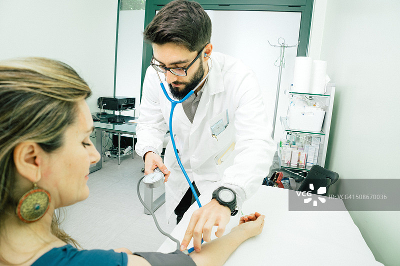 测量血压的年轻男医生图片素材