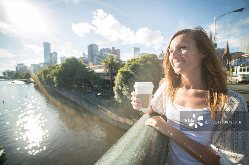 墨尔本：年轻女子在桥上俯瞰中央商务区图片素材