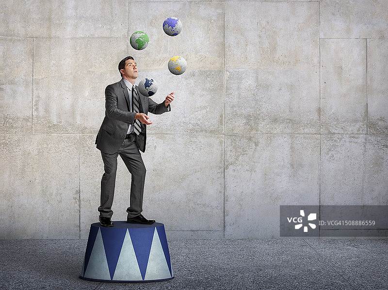 站在基座上玩转地球仪的商人图片素材