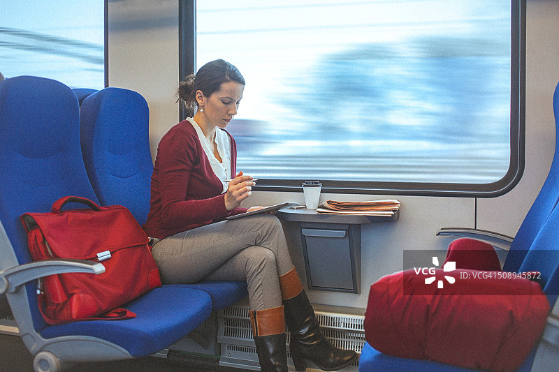 通勤时使用平板电脑的年轻女商人图片素材