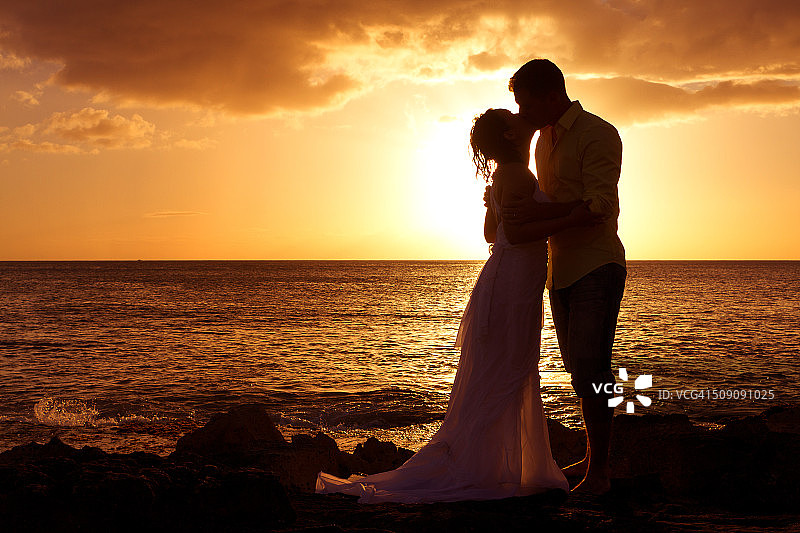 情侣在夏威夷海边剪影中接吻图片素材