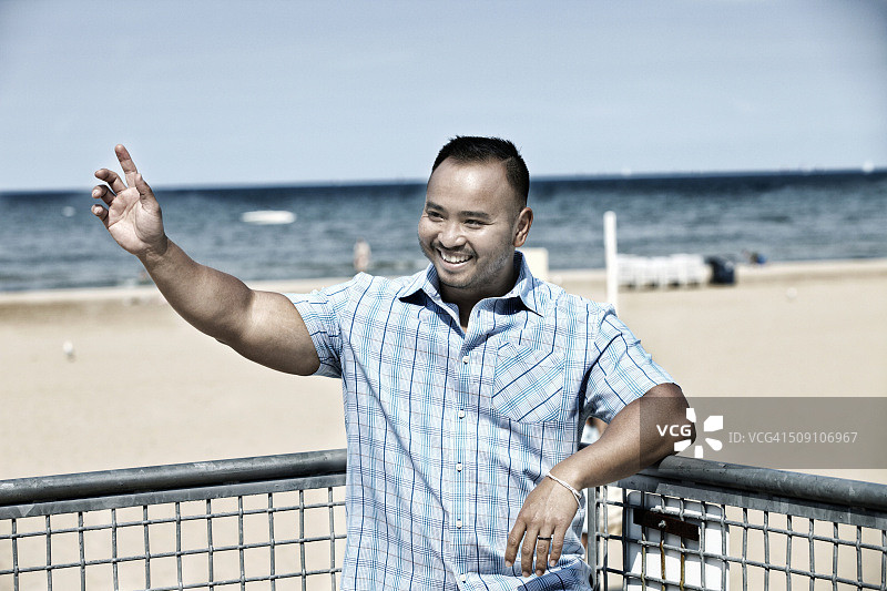男子站在芝加哥海滩上挥手图片素材