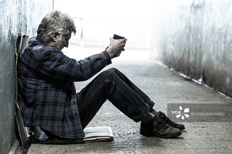 在地铁隧道里乞讨的年长流浪汉图片素材