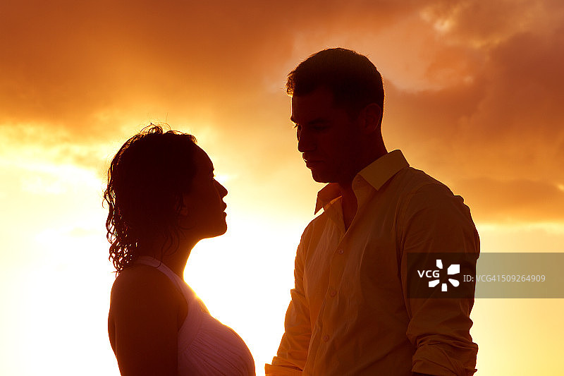 日落时分相互凝视的情侣轮廓图片素材