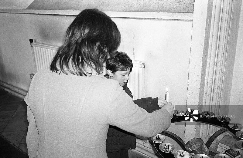 母子在教堂点燃祈祷蜡烛图片素材