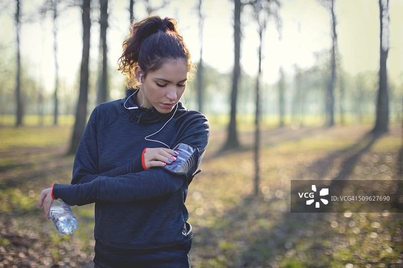 慢跑者从智能手机选择音乐图片素材