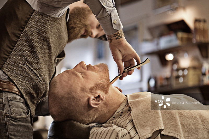 时尚复古的胡须理发师与一位胡须光头男顾客图片素材