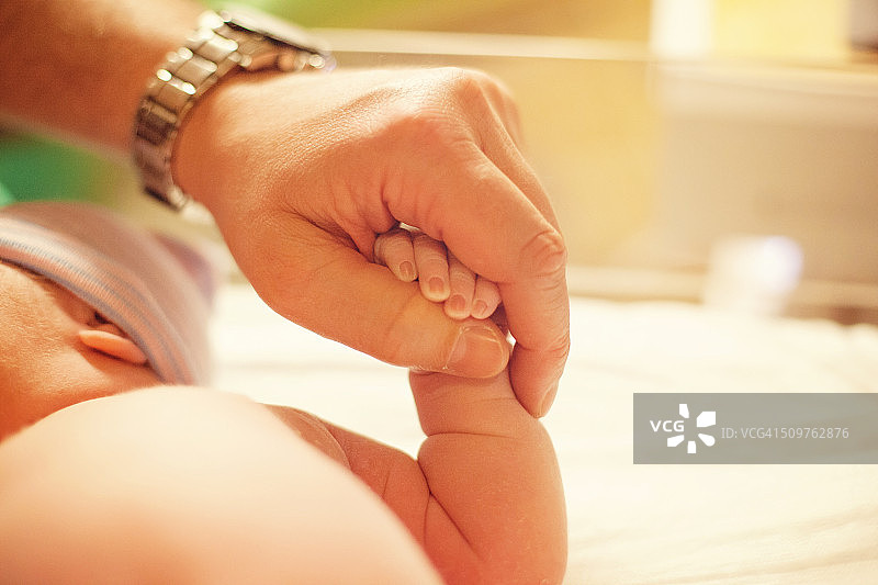 新生婴儿握着父亲的手图片素材