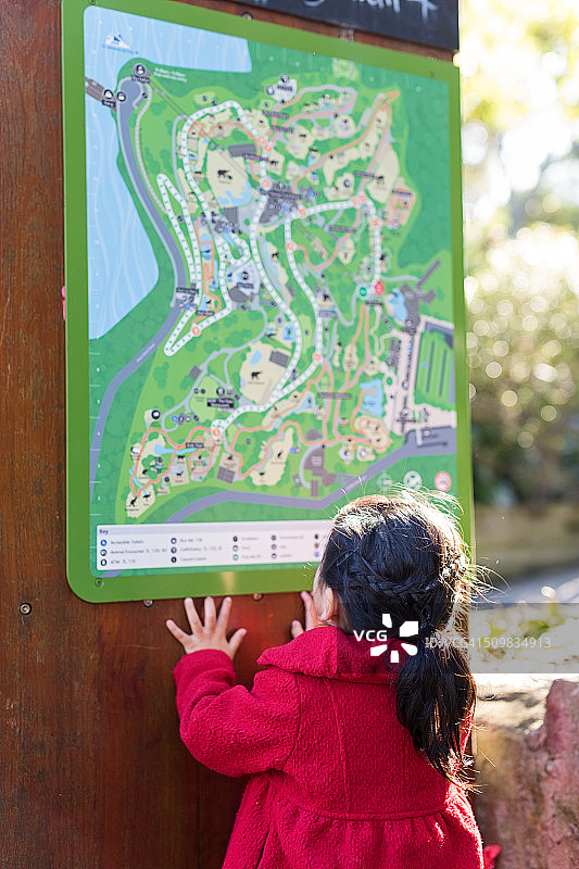 穿红色外套看地图的女孩图片素材