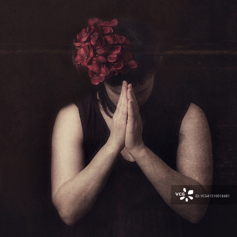 祈祷的头发戴红花的女人图片素材