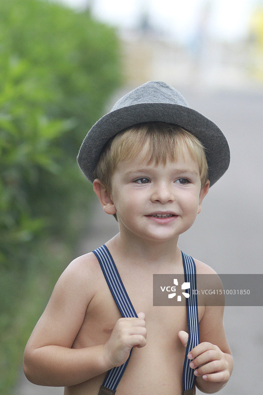 穿着吊带裤的无上衣男孩图片素材