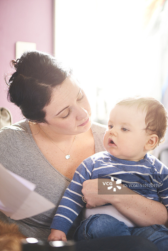 母亲与孩子坐在一起，为财务状况担忧图片素材
