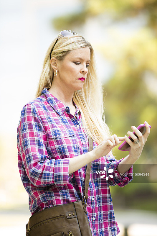 在市中心用手机发短信的女人图片素材