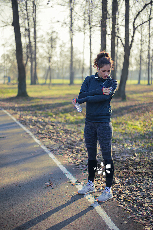慢跑者从智能手机选择音乐图片素材