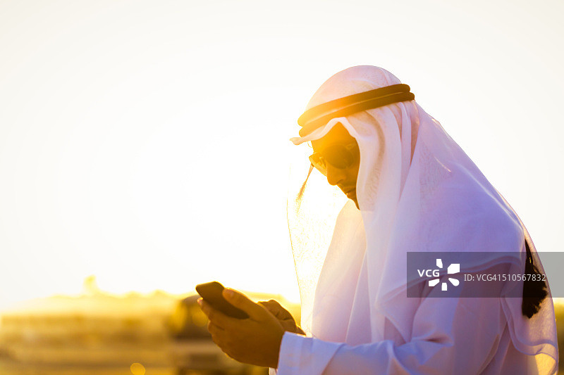 使用智能手机的现代阿拉伯男子图片素材