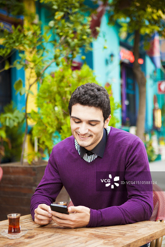 在户外彩色咖啡馆使用智能手机的学生图片素材