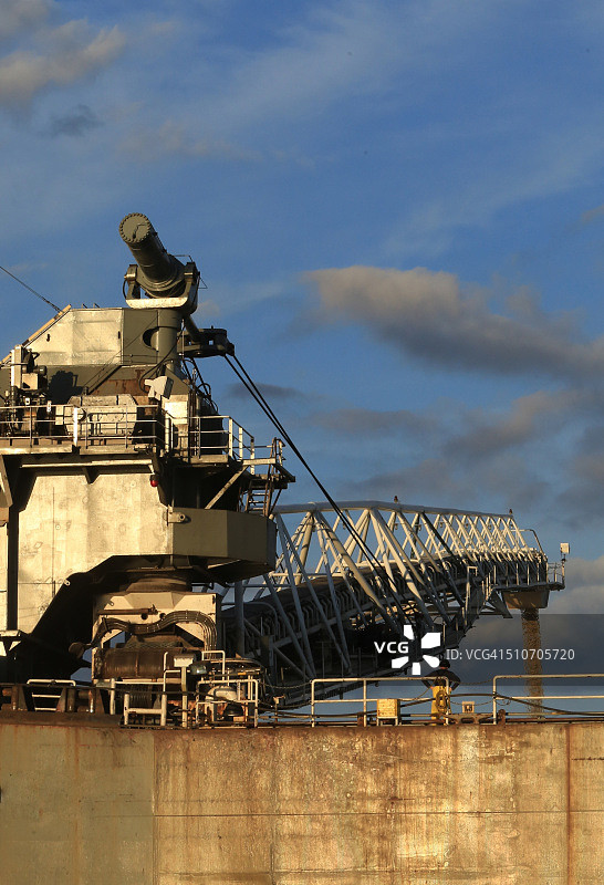 操作员观看沙子从机械输送机上落下图片素材