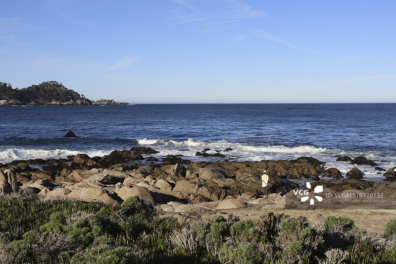 清晨阳光下的太平洋，一名女子站在岸边眺望大海图片素材
