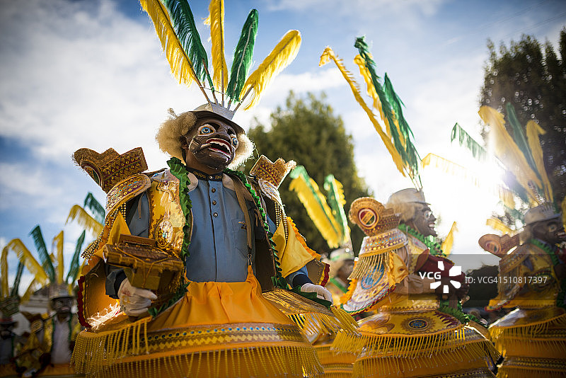 戴着面具和穿着服装的舞者，在玻利维亚科帕卡巴纳的坎德拉里亚圣母节上表演图片素材
