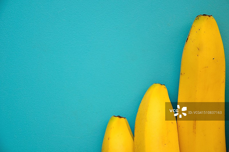 蓝色背景上的三根香蕉图片素材